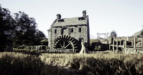 Historic Watermill Surrounded By Fields in a Rural Landscape During Daylight