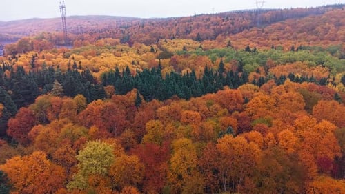 Des images prises par drone montrent un lac paisible reflétant des collines automnales aux couleurs automnales éclatantes.