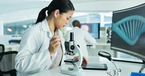 Focused Scientist Working with Microscope in Laboratory