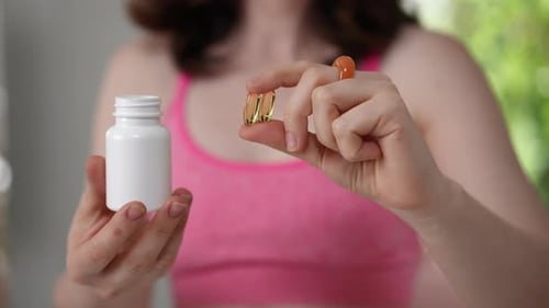 Woman Holding Vitamin Capsules Close Up