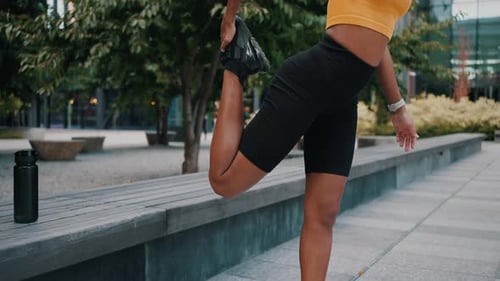 Woman Stretching Her Leg in Urban Park