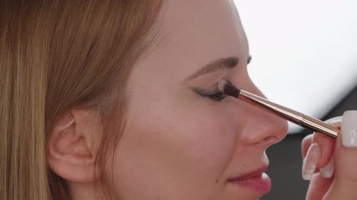 Woman Receives Eyeshadow Application with Brush, Close Up