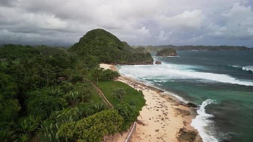 Aerial Drone View of Tropical Coastline in Indonesia with Palm Forest, Sandy Beach and Ocean Waves