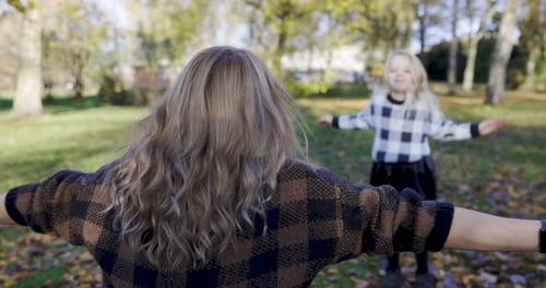 Mother and child daughter hugging and embracing at park