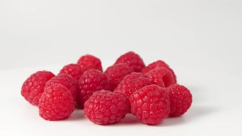 Raspberries rotate on a white background.