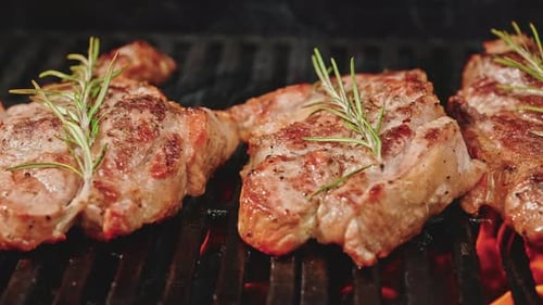 Frying Juicy Meat Steak with Spices and Herbs in Hot Coals Grilled Fire Flames and Smoke