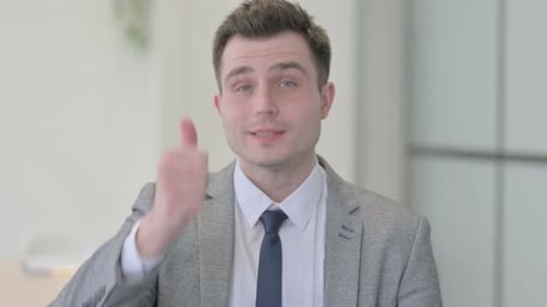 Man Gives a Thumbs Up in Office Setting