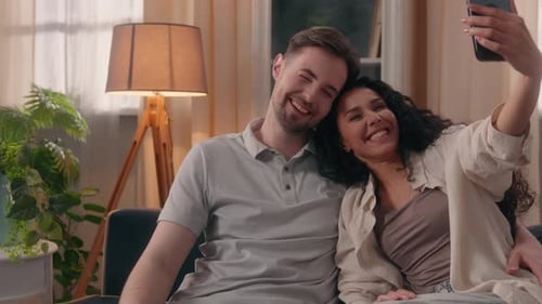 Happy Couple Taking Selfie on Sofa at Home