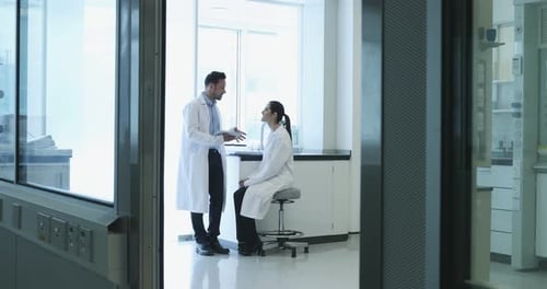 Scientists Discussing Research Data in a Bright Laboratory