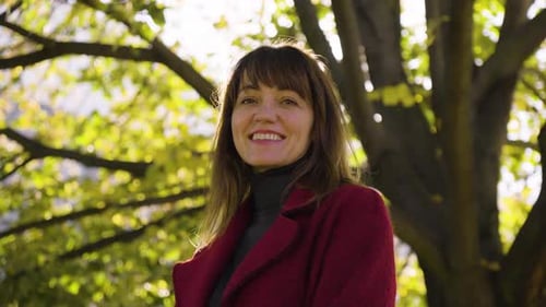 An Attractive Middleaged Caucasian Woman Laughs and Smiles at the Camera in a Park Closeup