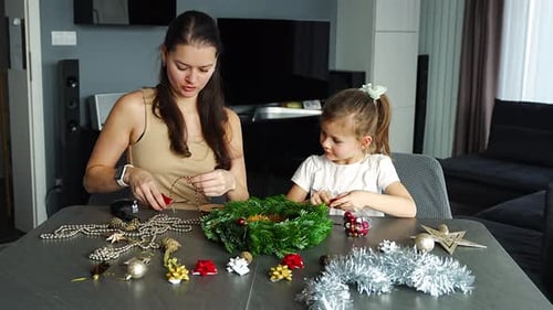 Woman and Girl Crafting Festive Holiday Wreath at Home