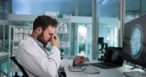 Scientist Rubbing Eyes in Brightly Lit Lab