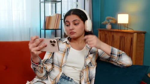 Young Woman Video Chatting on Mobile Phone at Home