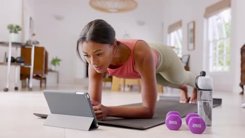 Mid Adult Fitness Woman Exercising at Home and Watching Training Videos On