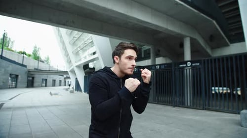 Fighter Man Training Boxing Punch on Urban Street. Portrait of Fitness Man