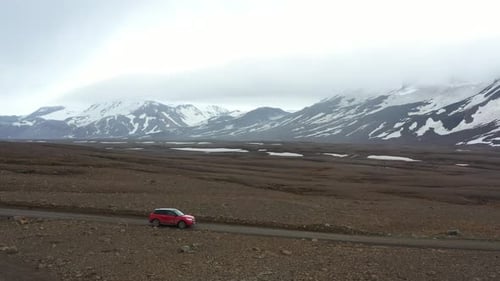 Une voiture solitaire parcourt un paysage islandais isolé