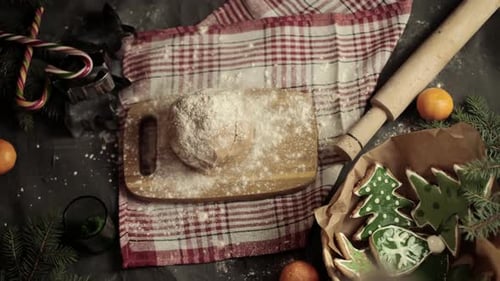 Close-up of a woman's hand making gingerbread cookies in the form of a Christmas tree and a gingerbr