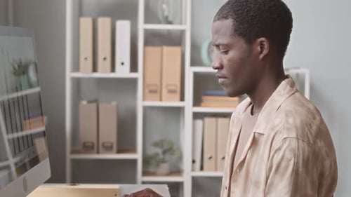 Homme noir fumant une cigarette Électronique pendant qu'il travaille au bureau