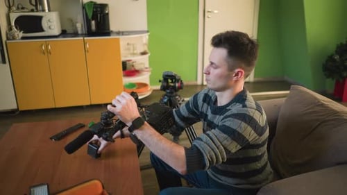 Man Adjusting Camera on Tripod with Microphone in Home Studio