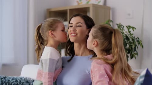 Mother Embracing Daughters, Receiving Affectionate Kisses Indoors