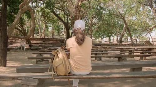 Femme repose assise sur un banc dans le parc