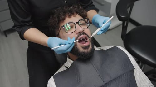 Man receives dental check-up from dentist in clinic during routine appointment