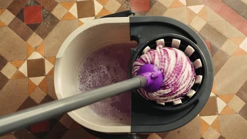 Cleaning Concept Closeup of Person Cleaning with a Mop and Bucket