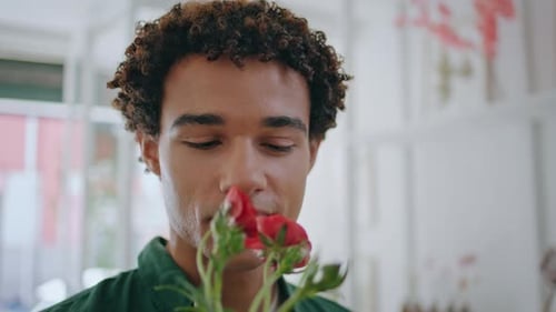 Young Adult Smells Fresh Flowers Indoors