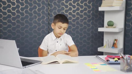 Unhappy and sad boy is bored of reading.
