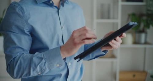 Man Using Stylus on Tablet Indoors