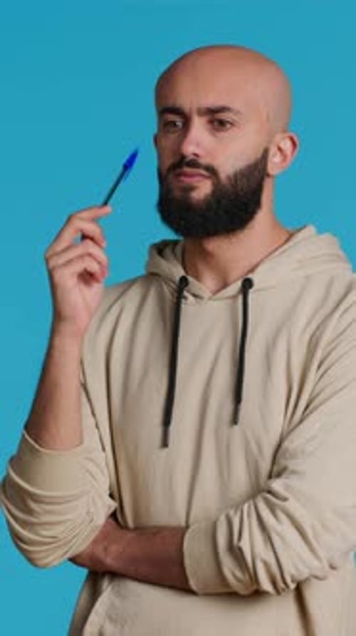Bearded Man Posing with Pen in Studio