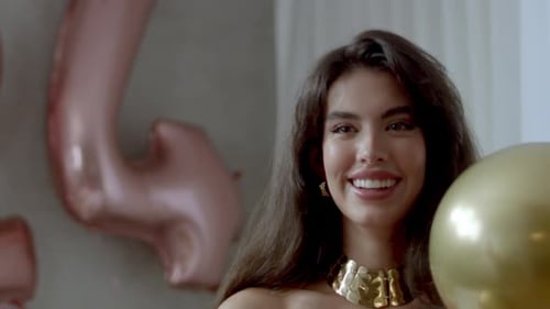Smiling Brunette Woman Holding Birthday Balloons