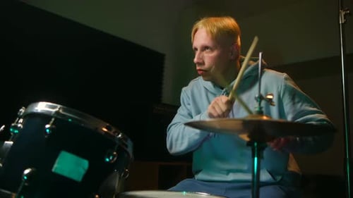 Blonde Man Playing Drums in a Music Studio