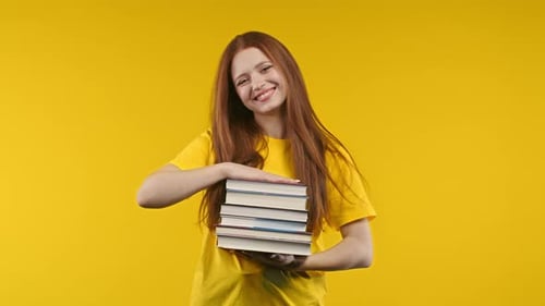 Ginger Clever Student Woman Holds Stack of University Books From College Library on Yellow