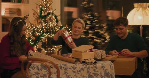 Friends Wrapping Christmas Gifts Together at Home