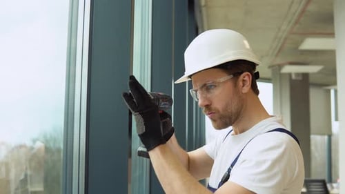 A Repairman in Uniform Fixing Pvc Windows in New Office