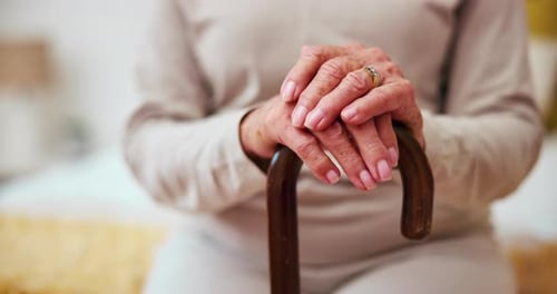 Senior Adult Hands Resting on Cane Indoors