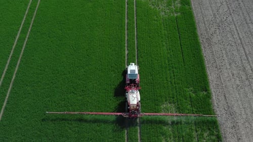 Farming Tractor Crop Sprayer on Green Field