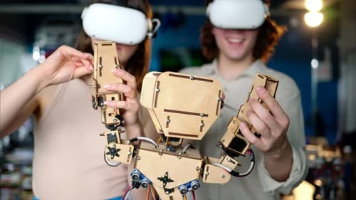 Two young engineers fixing a mechanical robot in the workshop, using VR virtual reality headsets