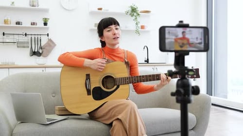 Caucasian Female Blogger Recording Guitar Lesson at Home Studio