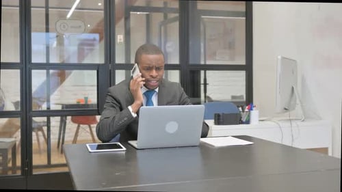 Frustrated Adult Talking on Mobile Phone in Office