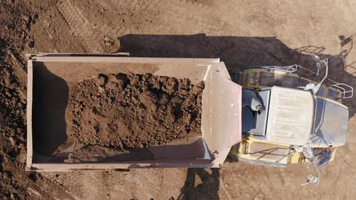 Excavator loading soil onto a Truck, Aerial view.