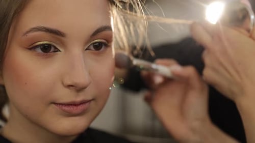 Woman Receiving Professional Makeup Application in Studio