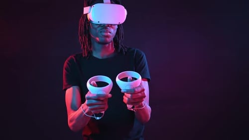 Man Using Virtual Reality Headset and Controllers