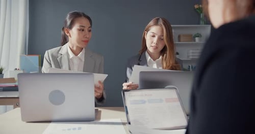 Empresários e empresárias asiáticos se reunindo para debater ideias sobre projetos trabalhando juntos.