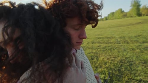 Young Couple in Love Embracing in Sunlit Meadow