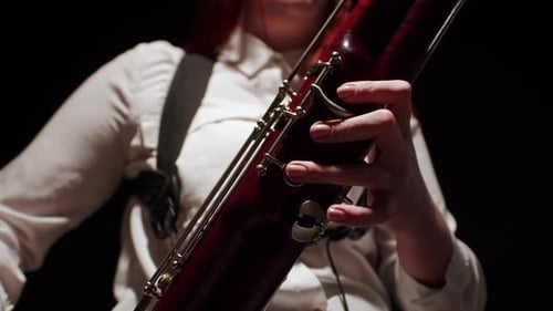 Woman Plays Bassoon with Fingers on Keys Closeup Front View