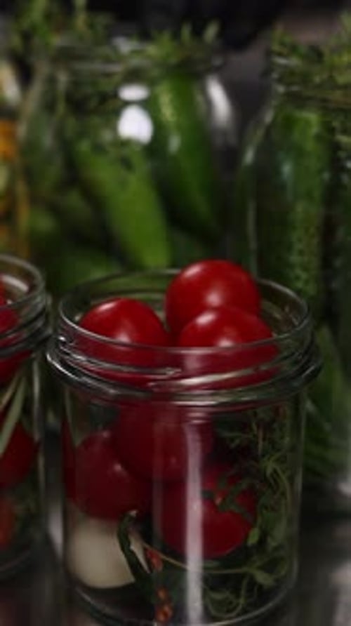 The chef preserves vegetables in the kitchen. Close-up