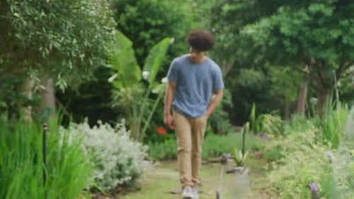 Happy biracial man walking in garden on sunny day