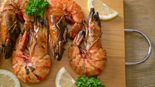 Grilled Tiger Prawns with Lemon on Wooden Board